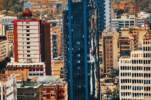 Downtown Nairobi close‑up showing a reflective glass tower surrounded by dense high‑rises