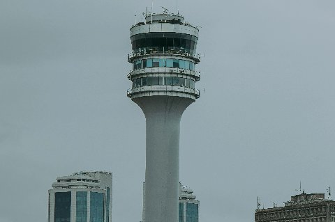 Tall observation tower rising above a coastal city skyline in Tanzania under overcast skies