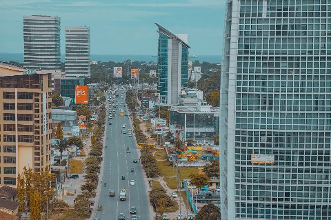 Aerial view down a busy avenue lined with skyscrapers toward the Indian Ocean in Tanzania
