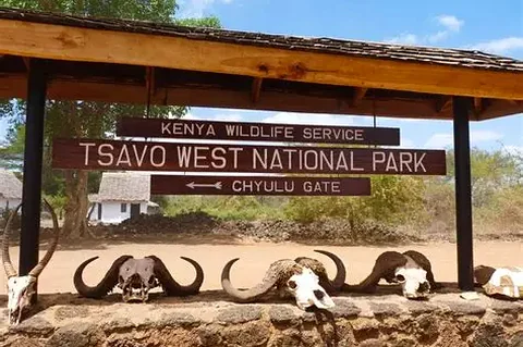Cartello d'ingresso al Parco Nazionale Tsavo Ovest al Chyulu Gate, con teschi di bufalo che incorniciano il messaggio di benvenuto.